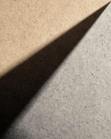 Light from the window on a textured cardboard surface with shadow.の写真素材