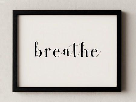 Black frame on white wall with the word breathe.の写真素材