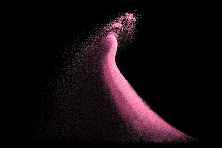 Pink powder explosion isolated on black background. Abstract pink dust cloud.の写真素材