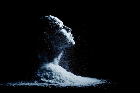 Portrait of a beautiful woman with flour on a black background.の写真素材