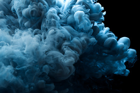 Blue ink in water on a black background. Abstract background for design.の写真素材