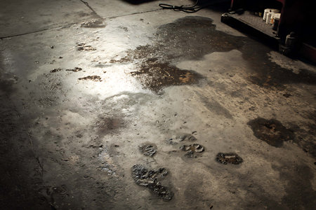 Puddle on the floor in a car repair station. Selective focus. Toned.の写真素材