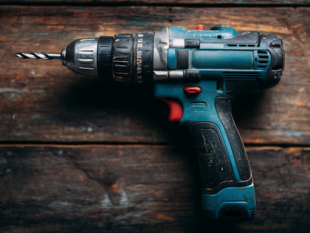 Cordless drill on a dark wooden background. Close-up.の写真素材
