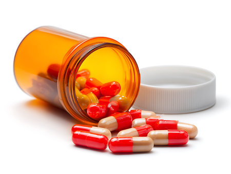 Pills spilling out of pill bottle isolated on white background with clipping pathの写真素材