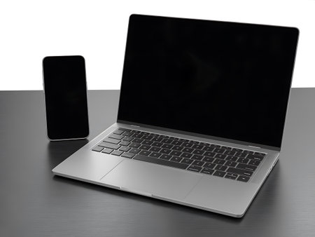 Laptop and smartphone on a black table. Isolated on white backgroundの写真素材