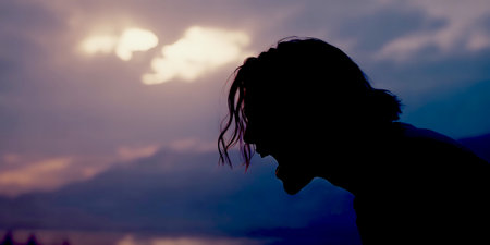 Silhouette of a young man on the beach at sunset.の写真素材