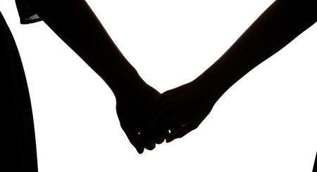 Silhouette of two hands holding each other on a white backgroundの写真素材