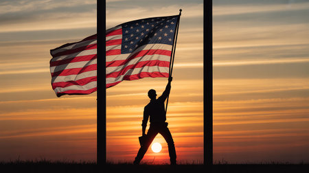 Silhouette of a man with the American flag in front of a sunsetの写真素材