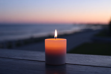 Candle on the beach at sunset. Selective focus with shallow depth of field.の写真素材