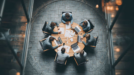 Top view of business people sitting at table and working together in officeの写真素材