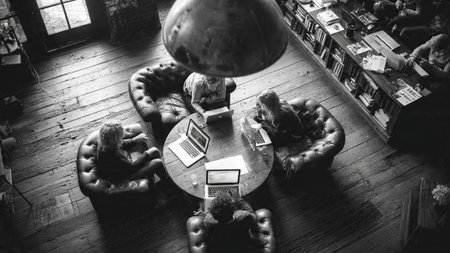 A group of people working on laptops in a modern libraryの写真素材