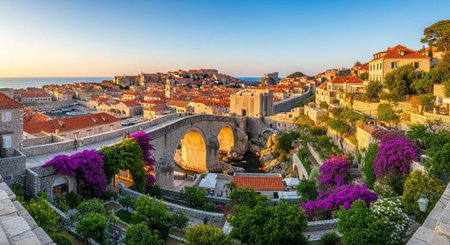 A panoramic view of a historic city with a stone bridge and vibrant purple flowersの写真素材