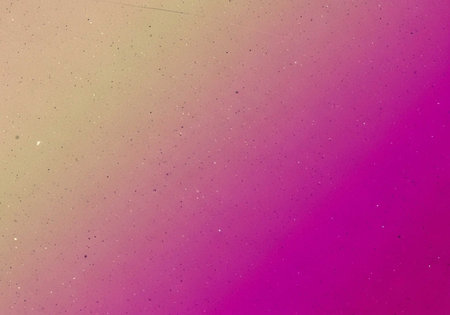 A vibrant gradient background with a mix of pink, purple, and beige colors and specklesの写真素材
