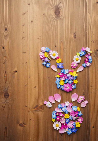 A colorful Easter bunny made of flowers on a wooden backgroundの写真素材