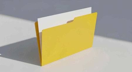 A yellow file folder with a white paper inside stands upright on a gray surface with a shadow cast.の写真素材