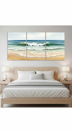 A triptych beach painting hangs above a light wood bed with white pillows, comforter, and modern nightstands with lampsの写真素材