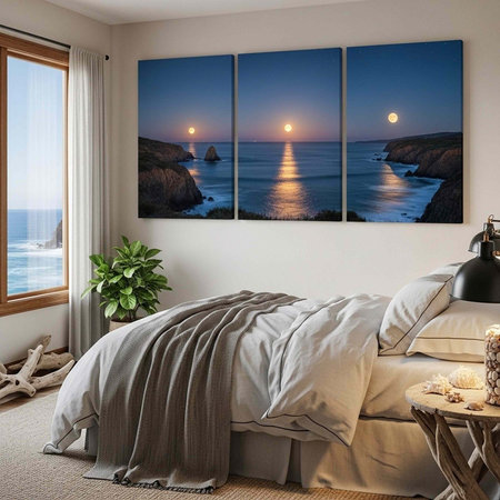 Calming bedroom with a large window, triptych ocean sunset art, white bed linens, and natural decor elementsの写真素材