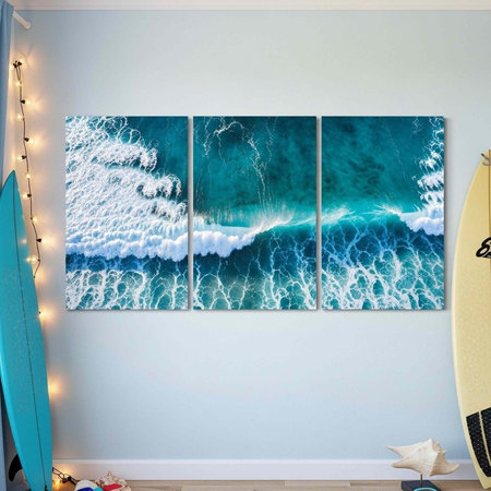Large triptych ocean wave art on wall, flanked by surfboards, string lights, and decorative starfish on wooden floorの写真素材