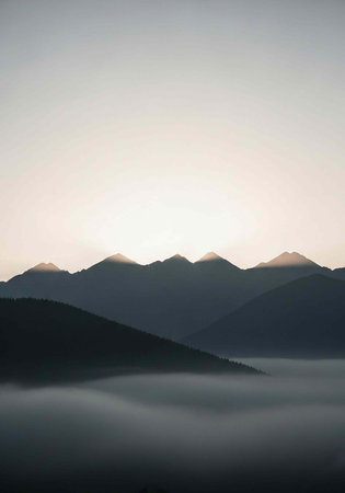 A serene mountain landscape at sunrise with misty valleys and rolling hillsの写真素材