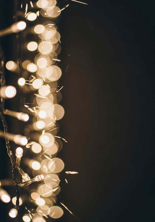 A string of warm glowing lights against a dark backgroundの写真素材