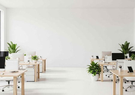 A sleek, modern office with wooden desks, white chairs, and green plants in white pots, set against a pristine white backgroundの写真素材
