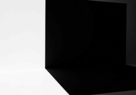 Close-up of black rectangular prism with sharp edges on white background, showcasing geometric shape and contrasting colorsの写真素材