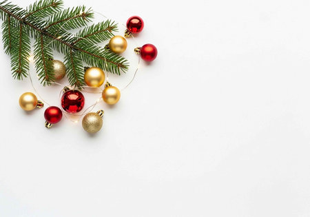 Festive Christmas scene with pine branch, red and gold ornaments, and white background for holiday decoration ideasの写真素材