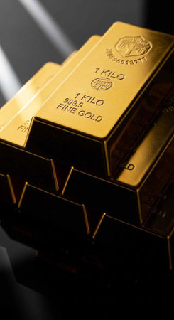 A stack of gold bars with a dark background and a beam of light shining on themの写真素材