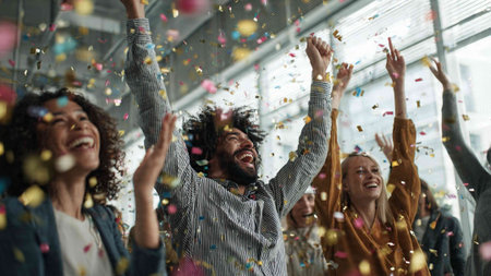 Cheerful business people dancing in confetti at corporate party in office