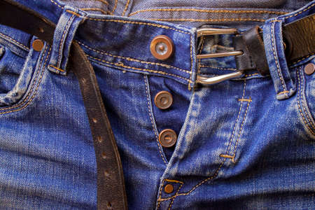 Blue men's or women's jeanse texile trousers indigo color with a black beltの写真素材