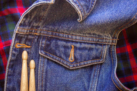 Two drum sticks of oak lie on the fabric of a Scottish cage and jeansの写真素材