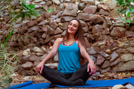 Young woman practicing and training yoga in the parck. Outdoor lady's sportの写真素材