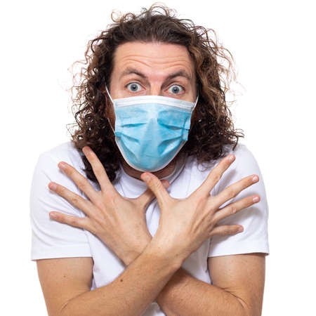 Man in medical mask looks in camera. Man stands in protective medical mask against viruses and infections isolated studio. Pandemic coronavirus epidemic covid-19の写真素材