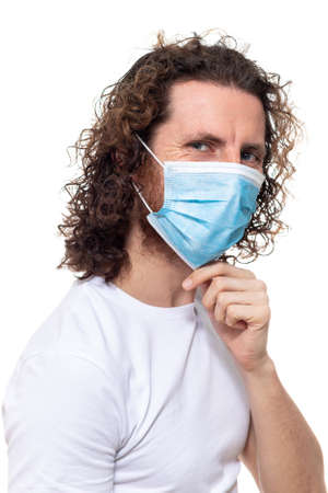 Man in medical mask looks in camera. Man stands in protective medical mask against viruses and infections isolated studio. Pandemic coronavirus epidemic covid-19の写真素材