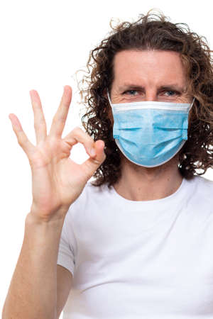 Man in medical mask looks in camera. Man stands in protective medical mask against viruses and infections isolated studio. Pandemic coronavirus epidemic covid-19の写真素材