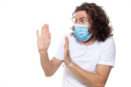Man in medical mask looks in camera. Man stands in protective medical mask against viruses and infections isolated studio. Pandemic coronavirus epidemic covid-19の写真素材