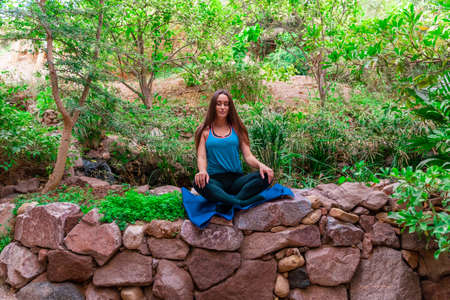 Young woman practicing and training yoga in the parck. Outdoor lady's sportの写真素材