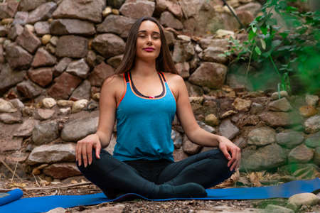 Young woman practicing and training yoga in the parck. Outdoor lady's sportの写真素材