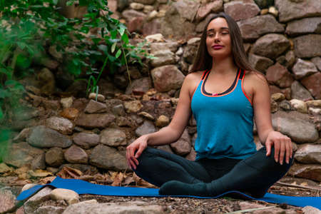 Young woman practicing and training yoga in the parck. Outdoor lady's sportの写真素材