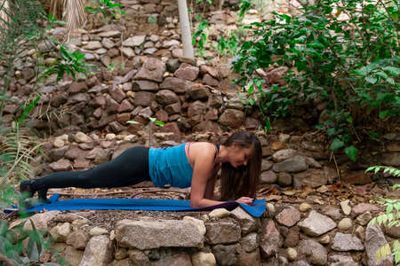 Young woman practicing and training yoga in the parck. Outdoor lady's sportの写真素材