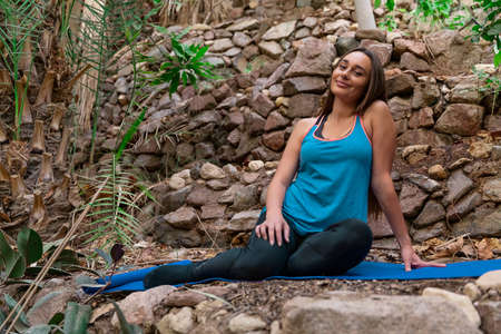 Young woman practicing and training yoga in the parck. Outdoor lady's sportの写真素材