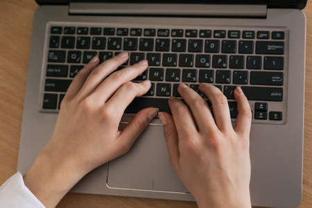 Woman drinking coffee and using digital tablet in the morning. Hands on laptop. Work from home