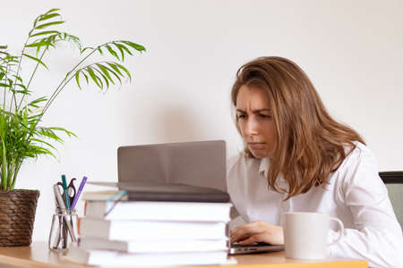 Woman working on laptop at home office while drinling coffee. Web conectionの写真素材
