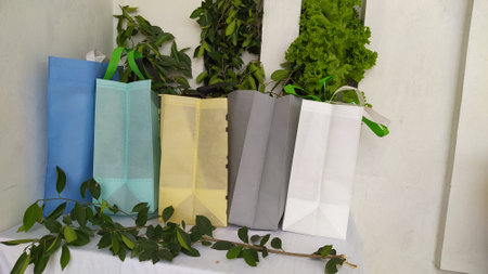 Colorful non woven fabric bags with green leaves isolated on white table. ECO Shopping bags for mock-up. Copy space  Concept for text. New Year and Christmas Gift Bags.の写真素材