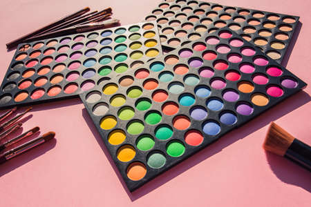 Color eyeshadows palettes with tools for makeup on pink backgroundの写真素材