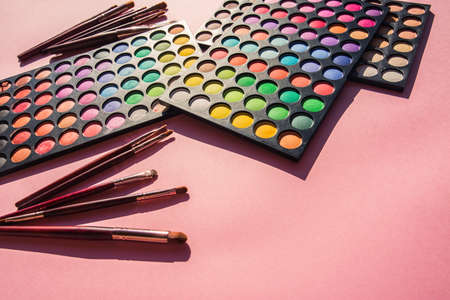 Color eyeshadows palettes with tools for makeup on pink backgroundの写真素材