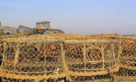 Ready for dawn - fishing tackle stacked on the harbourの写真素材