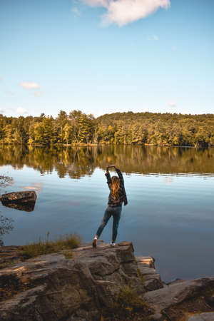 Portrait of a woman by a lake in the wilderness.