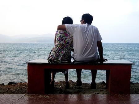 Love birds. A romatic couple sitting on a quiet beach.の写真素材