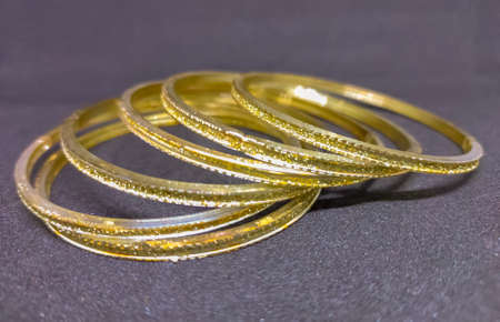View of golden glass bangles in black background